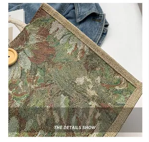 Close-up of computerized stitching and floral tapestry fabric on a women's bag.