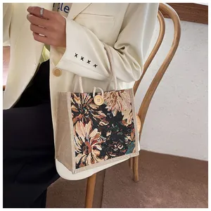 Close-up of vintage floral embroidery on small cloth tote bag with rope handle