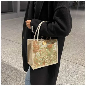 Detailed view of floral tapestry tote bag with rope handles and button closure for women