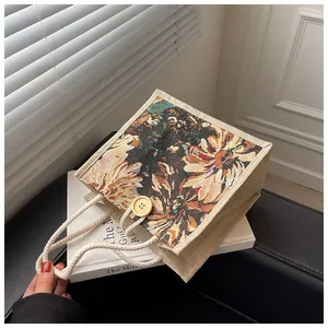 Detailed view of floral tapestry tote bag with rope handles and wood button