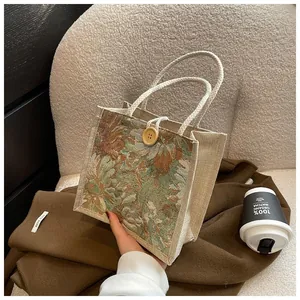 Close-up of woven floral tote bag featuring a rustic button closure and rope handles