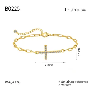 Detailed macro shot of 14K gold plated paperclip bracelet with zircon cross pendant