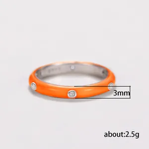Close-up detail of a 3mm orange enamel ring with zircon stones weighing about 2.5g