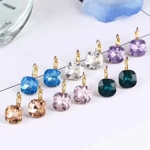 Detailed macro view of multiple colorful square crystal leverback earrings in gold.