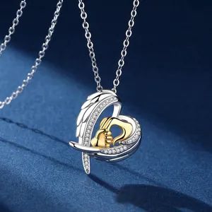 Close-up of angel wing heart necklace featuring big hand holding small hand design