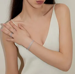 Détail d'un bracelet gourmette cubain argenté serti de brillants porté sur le poignet