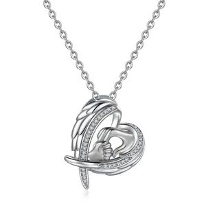 Detail of silver heart necklace with angel wings and holding hands centerpiece.