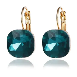 Detailed close-up of square emerald green crystal earrings in gold leverback setting