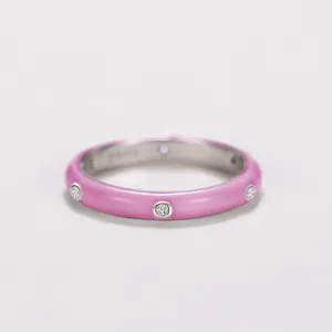 Macro detail of a minimalist pink enamel ring featuring sparkling cubic zirconia stones