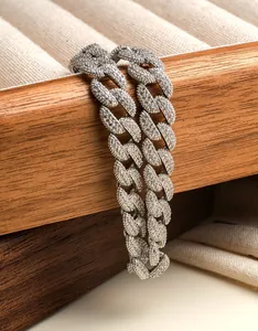 Vue macro détaillée d'un bracelet gourmette cubaine argenté serti sur une boîte en bois