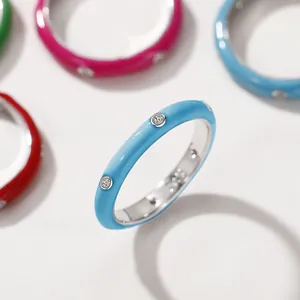 Macro view of a minimalist light blue enamel ring set with clear zircon stones
