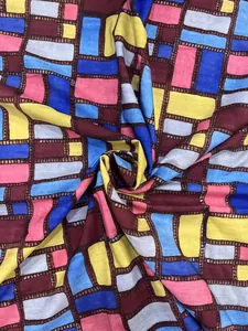 Close-up of lightweight summer dress fabric featuring colorful geometric block print pattern.