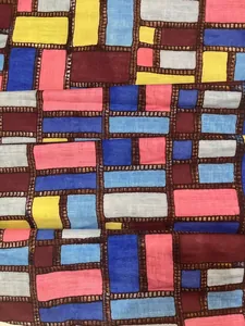 Close-up macro view of the colorful geometric block print on summer dress fabric