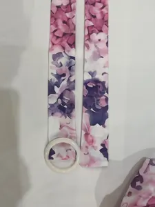 Close-up detail of floral print waist belt with round white buckle for a shirt dress