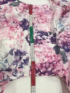 Detailed vertical measurement of pink floral print shirt dress showing scale and fabric