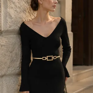 Detailed shot of golden geometric buckle elastic waist belt on elegant black dress