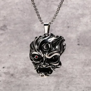 Détail d'un collier avec pendentif masque de démon vintage en acier inoxydable