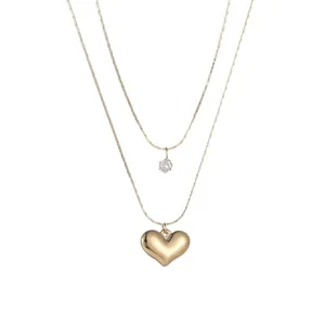 Elegant 18K gold plated double-layered necklace featuring a puffed heart and zirconia pendant.