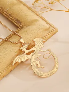 Nahaufnahme einer goldfarbenen Drachen-Halskette auf einem Vintage-Bilderrahmen.