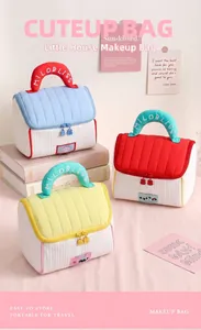Detail of house-shaped makeup bags in blue, red, and yellow pastel colors.