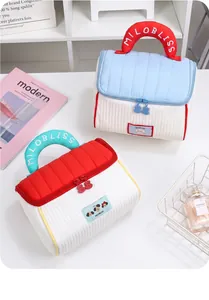 Detail of house-shaped quilted makeup bag with MILOBLISS handle and cute zipper.