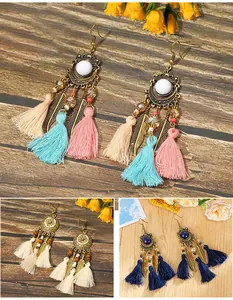 Detailed view of bohemian tassel earrings with feather charms in multiple colors