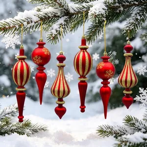 Detailed view of red and gold painted Christmas ornaments hanging on a snowy tree.