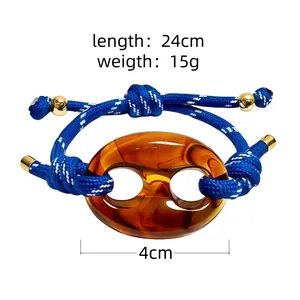 Macro detail of blue woven pig nose bracelet with dimensions and weight information