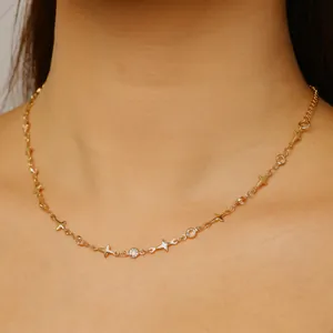 Vue détaillée d'un collier doré délicat orné d'étoiles scintillantes et de breloques en cristal