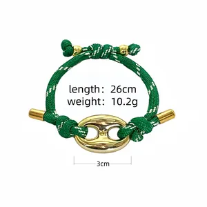Detail view of green braided bracelet showing length 26cm and 3cm center link.
