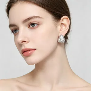 Detail of retro embossed textured irregular triangle stainless steel stud earrings on model