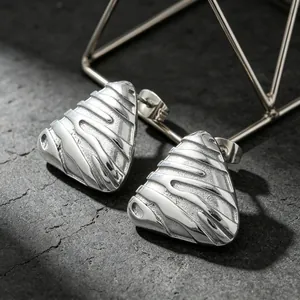 Close-up of vintage embossed textured irregular triangle stainless steel stud earrings