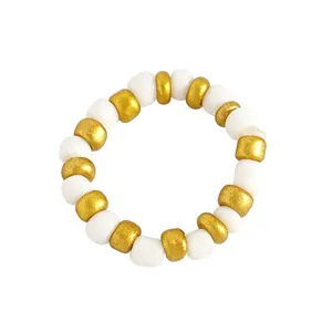 Close-up macro detail of a white and gold beaded ring featuring elegant acrylic pearls