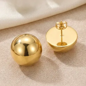 Close-up detail of high-polished gold stainless steel hemisphere dome stud earrings
