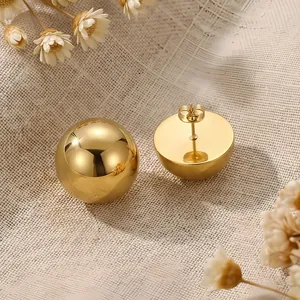 Close-up detail of golden stainless steel half-ball stud earrings with polished finish.