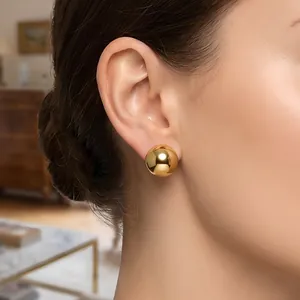 Polished gold stainless steel dome stud earrings for women in a modern minimalist style.