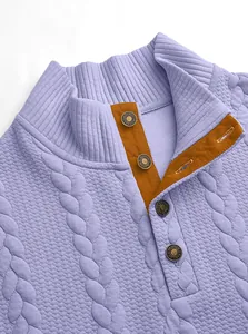 Detail of purple Henley sweater with textured knit and contrast orange placket.