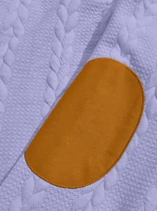Macro view of purple jacquard knit sweatshirt fabric with cognac oval elbow patch