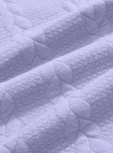 Detailed macro shot of lavender jacquard textured fabric with floral embroidery patterns