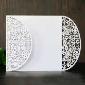 Detailed view of elegant white laser-cut floral wedding invitation card