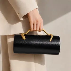 Close-up of black PU evening clutch with golden snake-shaped handle