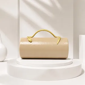 Elegant beige cylinder evening bag with gold snake-shaped handle detail.