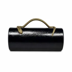 Detailed view of glossy black cylinder evening bag with gold snake handle