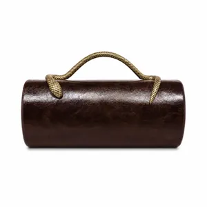 Close-up of dark brown barrel evening bag featuring a golden snake-shaped handle