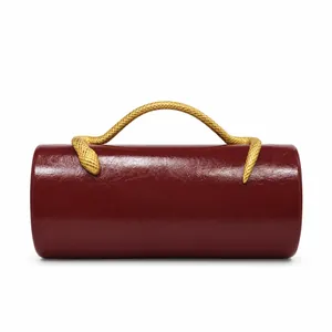 Detailed view of a burgundy PU leather barrel evening bag with a gold snake handle