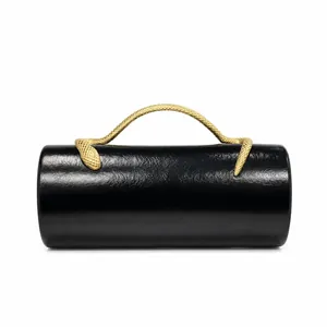 Close-up of a black PU cylindrical evening bag with a textured gold snake handle