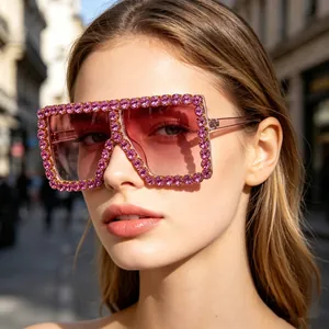 Close-up of model wearing oversized pink rhinestone sunglasses with gradient lenses.
