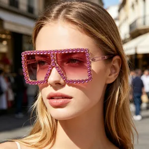 Close-up of oversized square sunglasses with sparkling pink rhinestone accents
