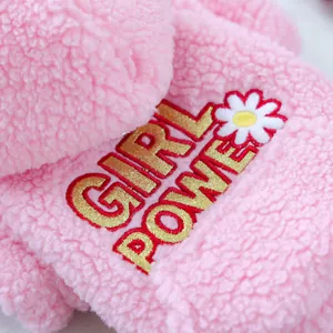 Macro dettaglio della felpa rosa in pile per animali con ricamo glitter Girl Power