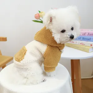 Primo piano di un cane bianco che indossa una calda felpa in pile Sherpa crema.